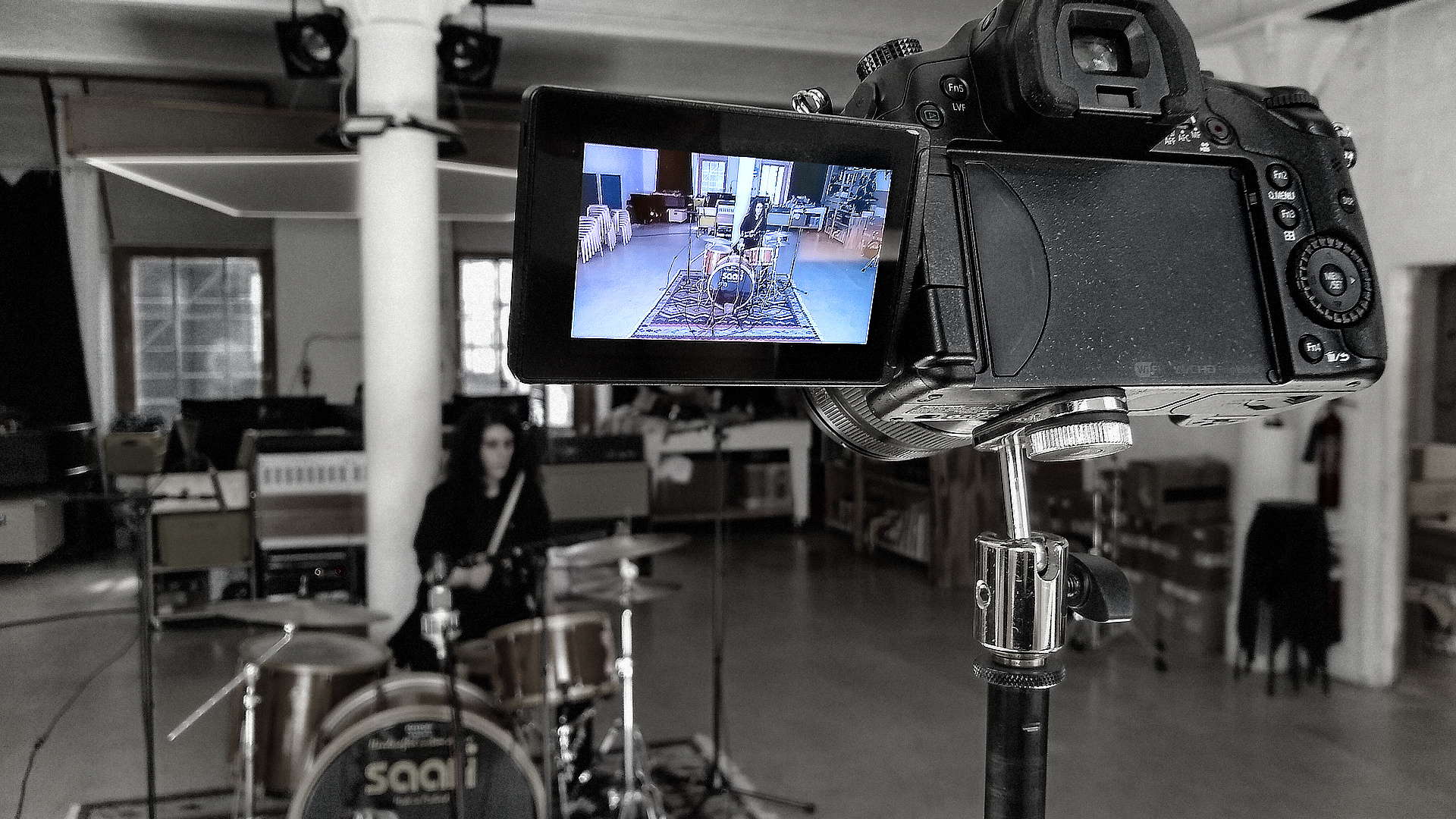 Camera shooting Sara Neidorf sitting at drumkit